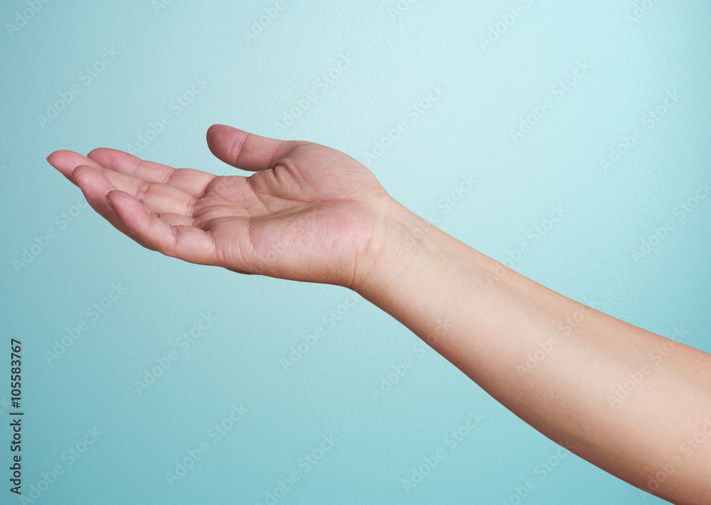 Close-up of  hand isolated on blue background. Palm up