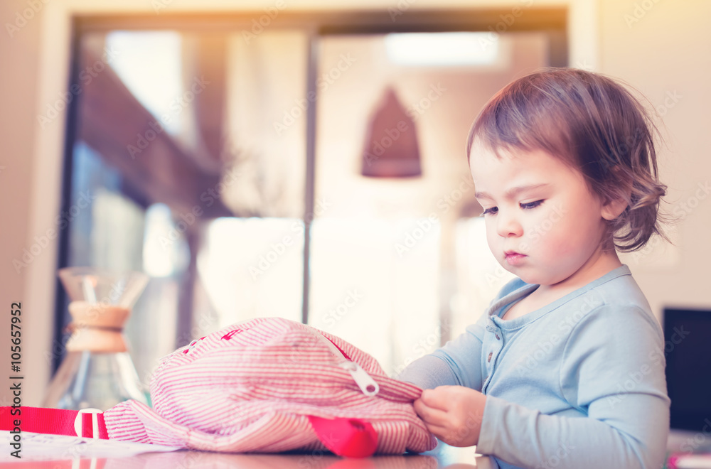 Toddler girl preparing her backpack