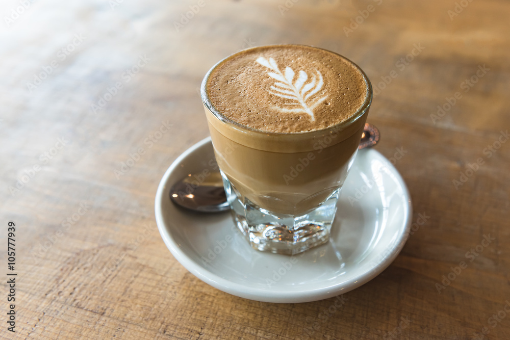 glass of latte coffee on wooden table