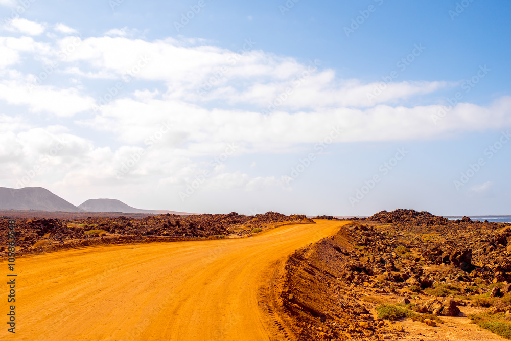 Corralejo沙丘的地面道路，背景是西班牙富特文图拉岛上的山脉