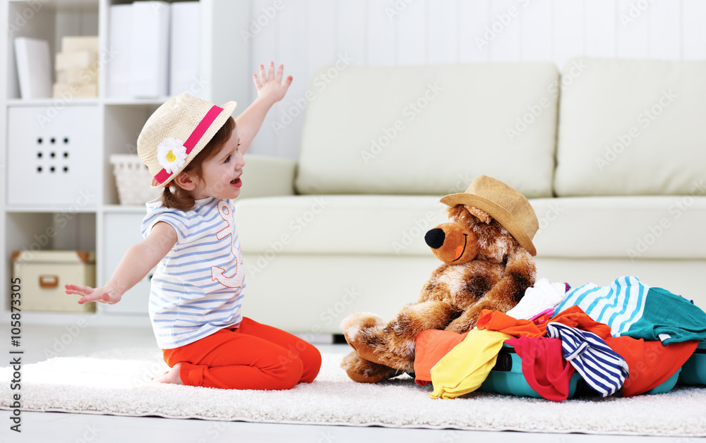 happy child girl collect suitcase on vacation