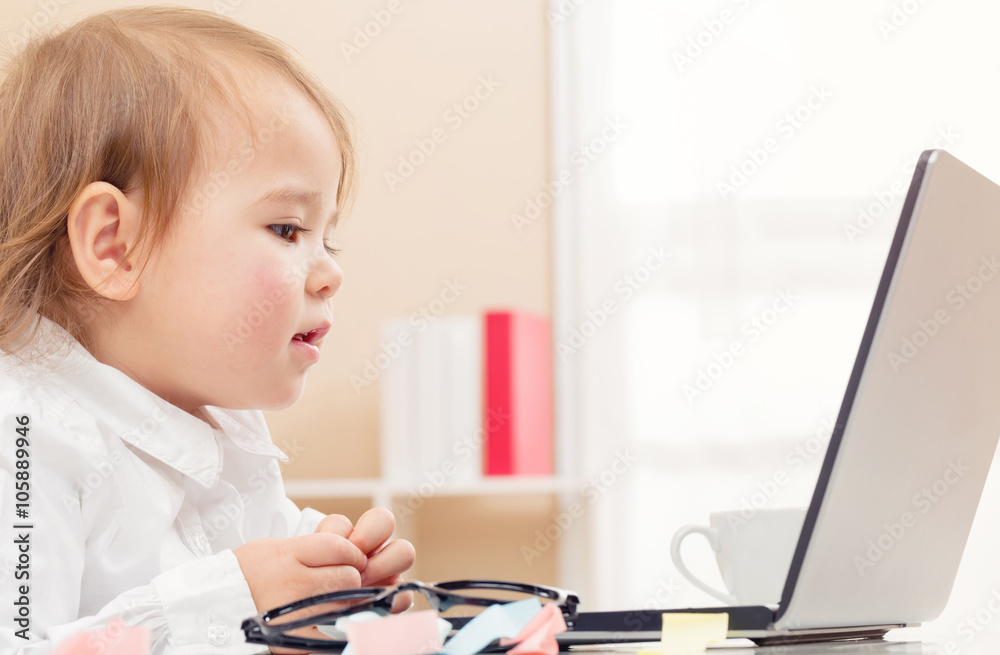 Happy toddler girl on her laptop