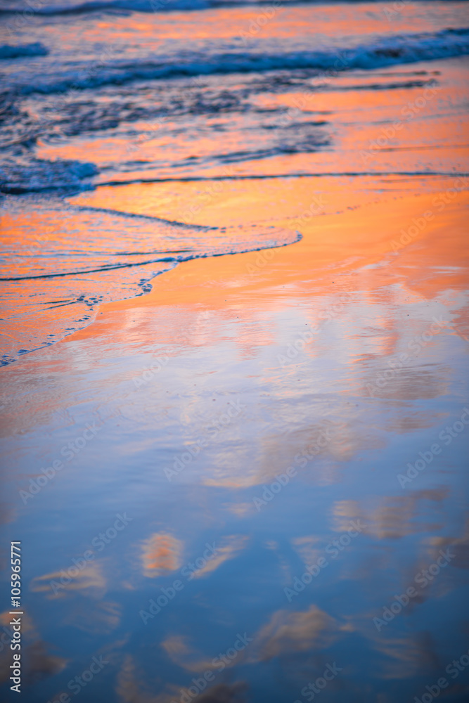 Beach with glossy surface reflecting beautiful seascape on the sunset in Maspalomas on Gran Canaria 