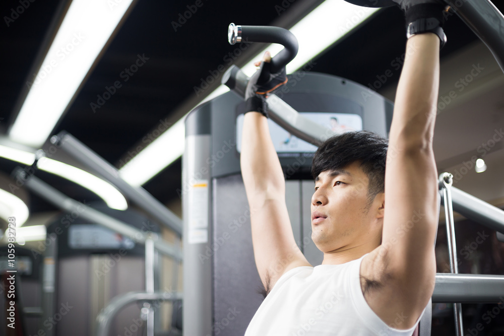 young handsome man works out in modern gym