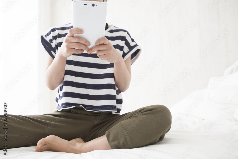 Women are looking at the tablet on the bed