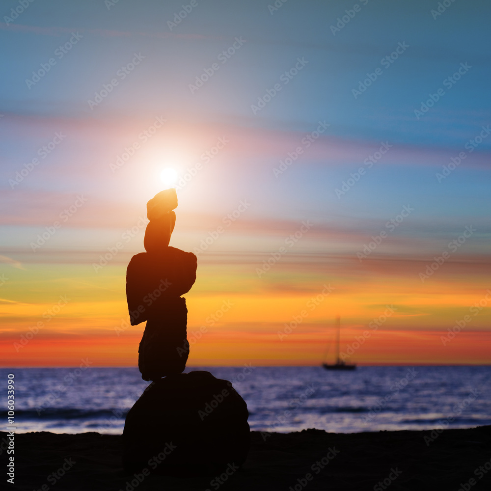 海上日落背景石金字塔