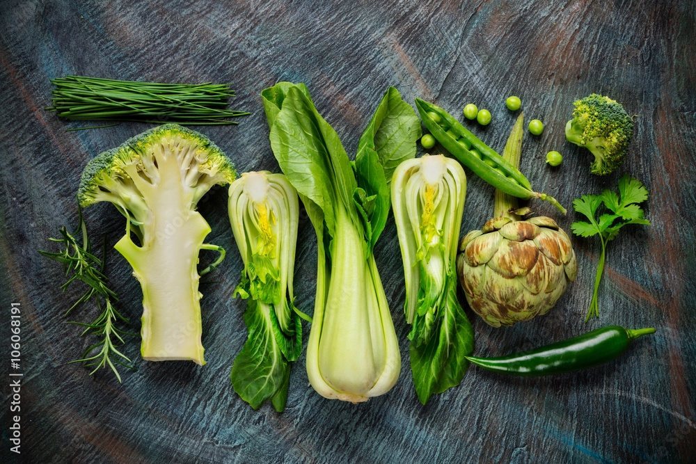 Collection of fresh green vegetables on black stone