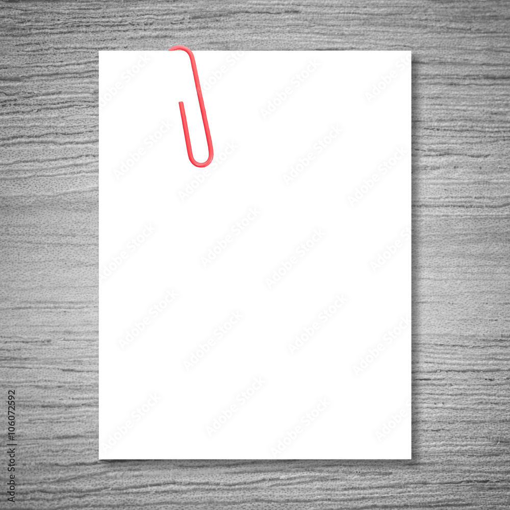 White blank space and red paper clip on wood background