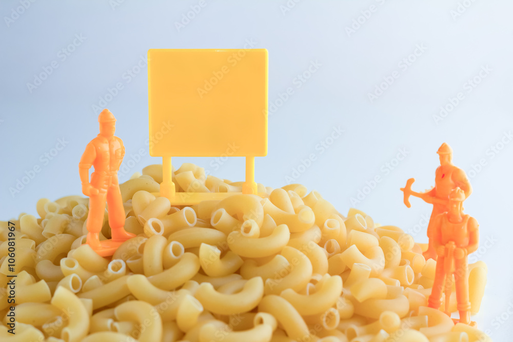 uncooked pasta and set of workmen on white table