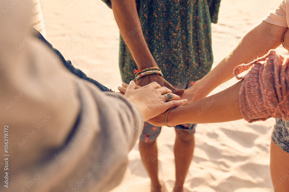 Friends at the beach putting hands together