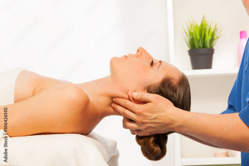 Masseur doing neck massage on woman in spa salon