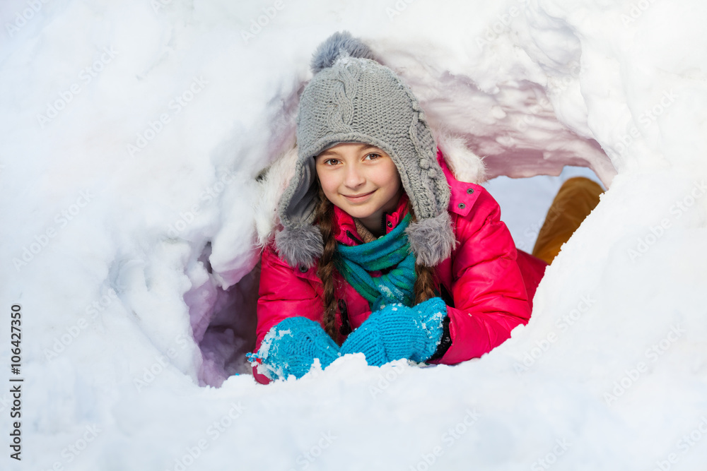 女孩在外面她挖的雪隧道里玩耍