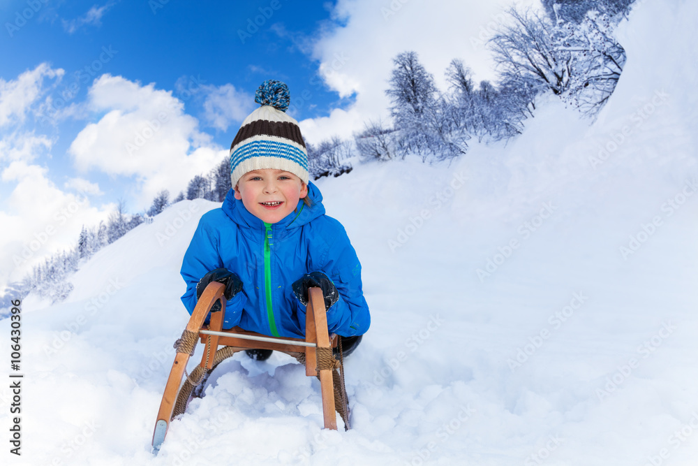 山里的小男孩在雪橇上滑行