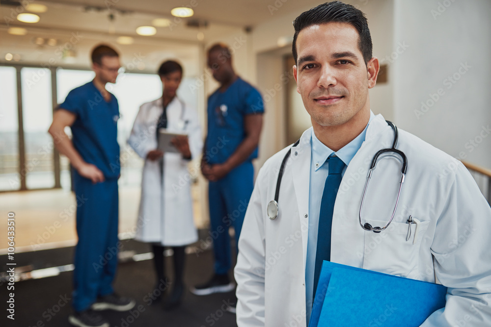 Male doctor with colleagues in background