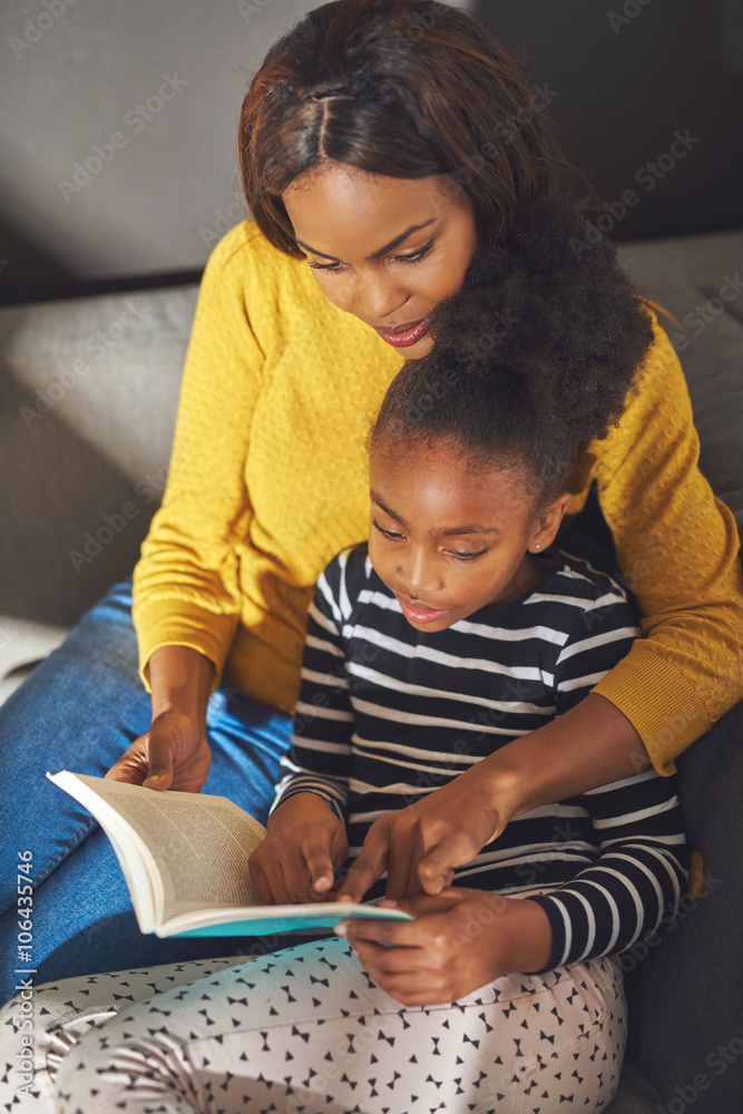 Overhead view mom and daughter reading book