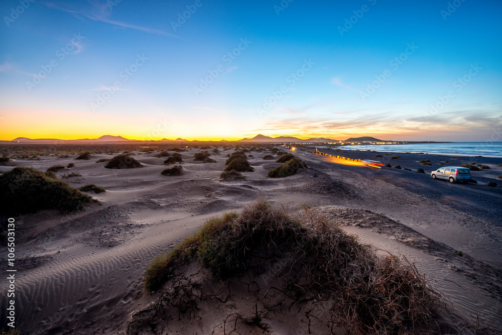 Famara sand dunes in the evening with car lights and beautiful sky on Lanzarote island in Spain