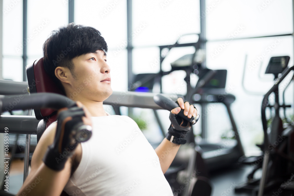 young handsome asian man works out in modern gym