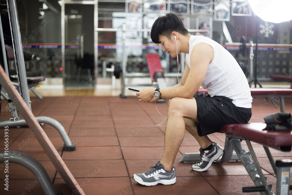 young handsome asian man works out in modern gym