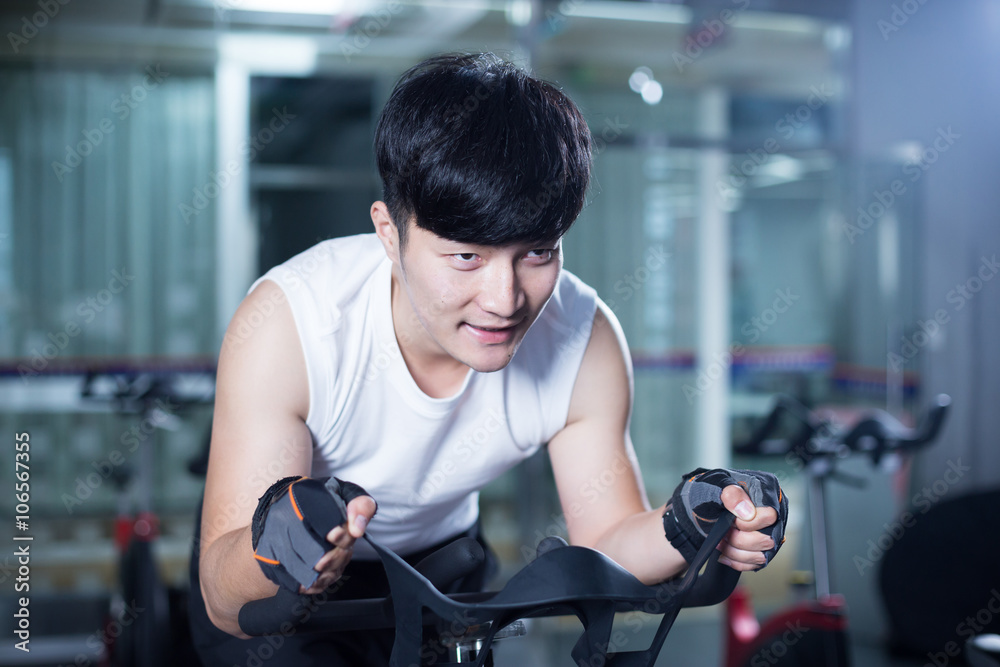 young handsome asian man works out in modern gym