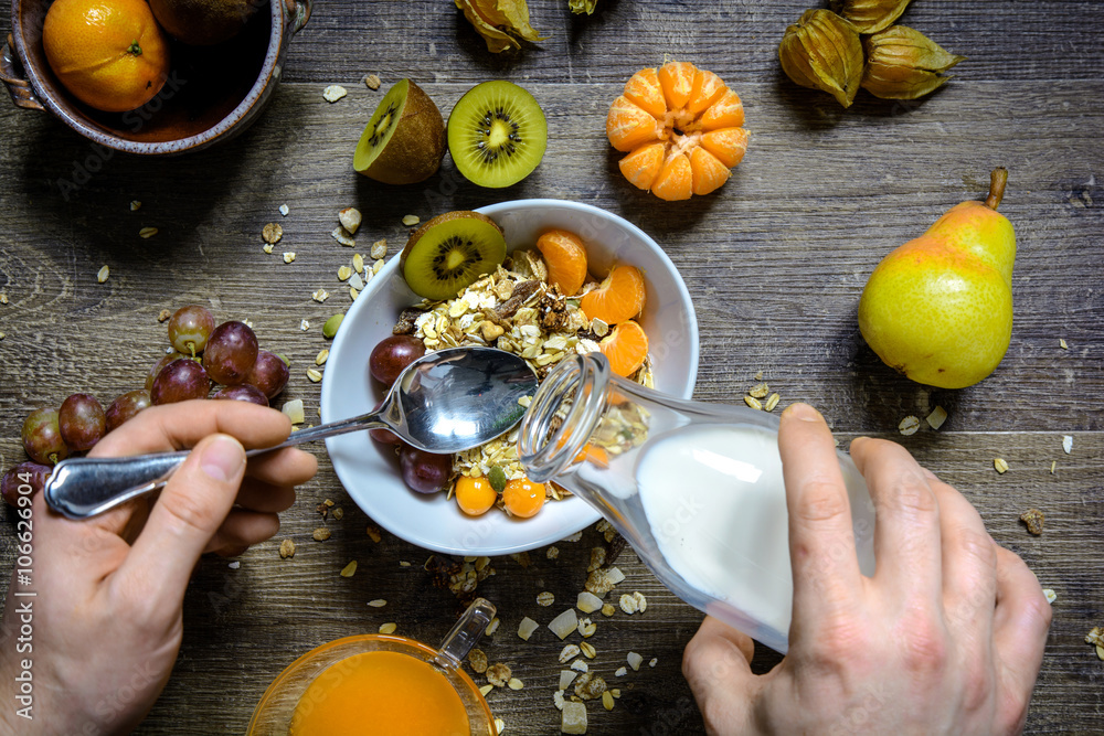 gesundes Frühstück aus Müsli und Obst zubereitet auf altem Holztisch