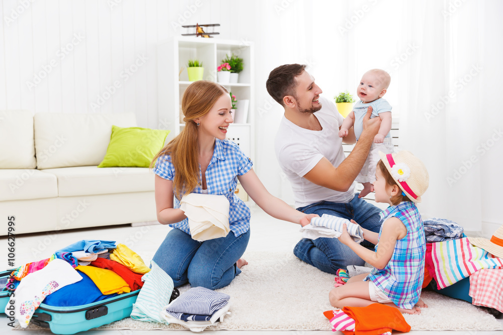 happy family mother, father and two children packed suitcases fo