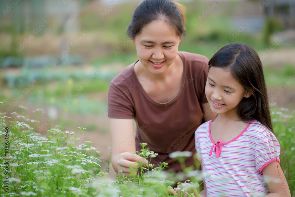 Happy Asian daughter gardening with her mother