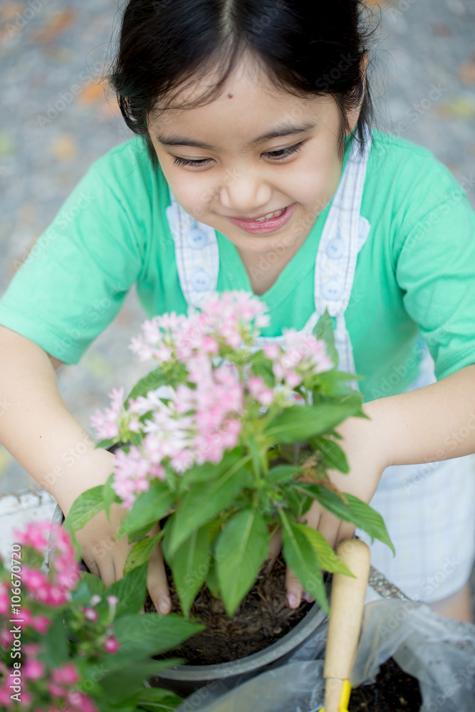 Little Asian child planting flower