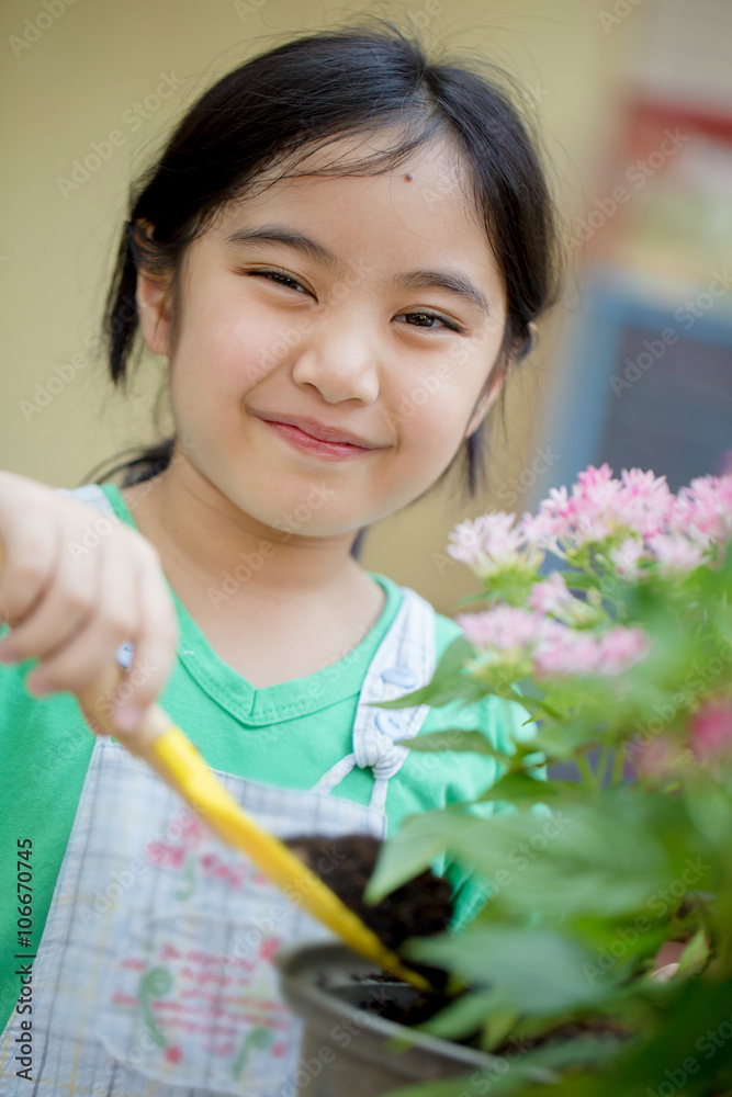 Little Asian child planting flower