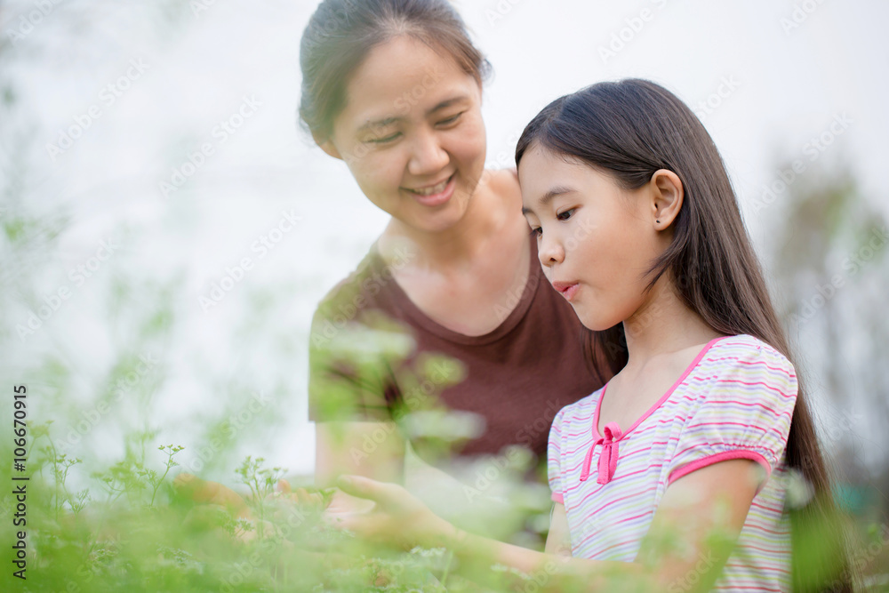 Happy Asian daughter gardening with her mother