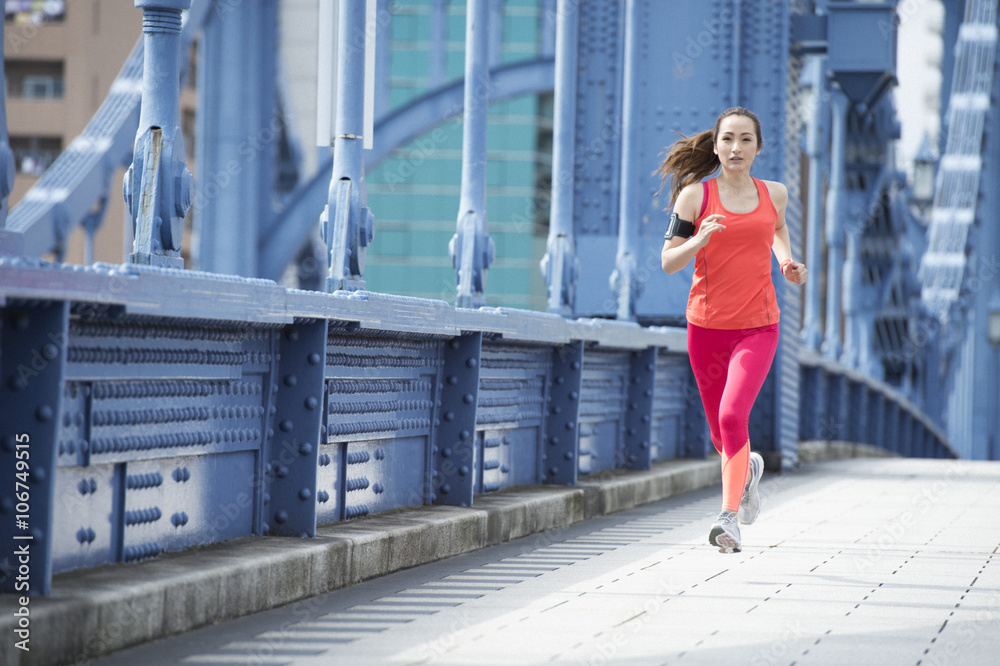 Young woman running on the bridge