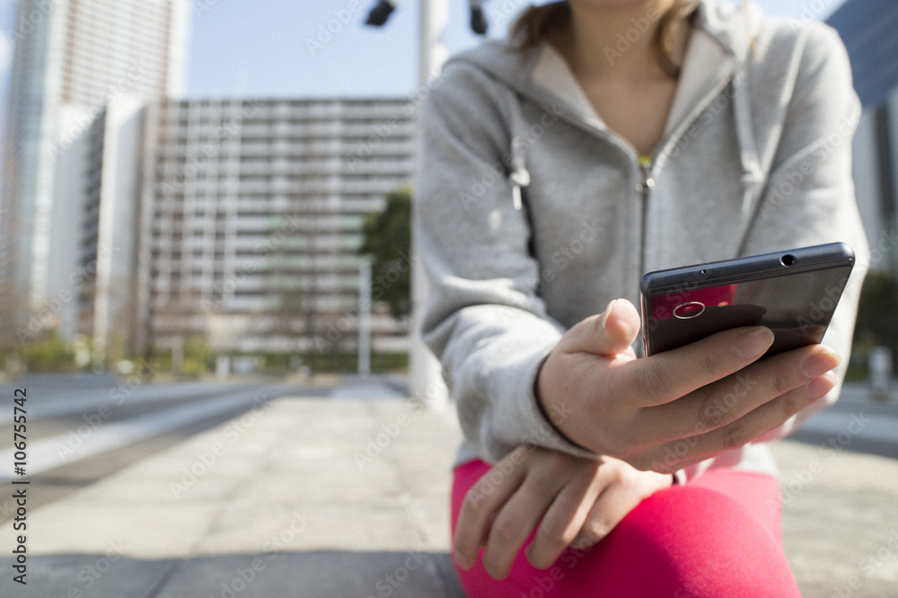 Women wearing sportswear, looking at the smartphone