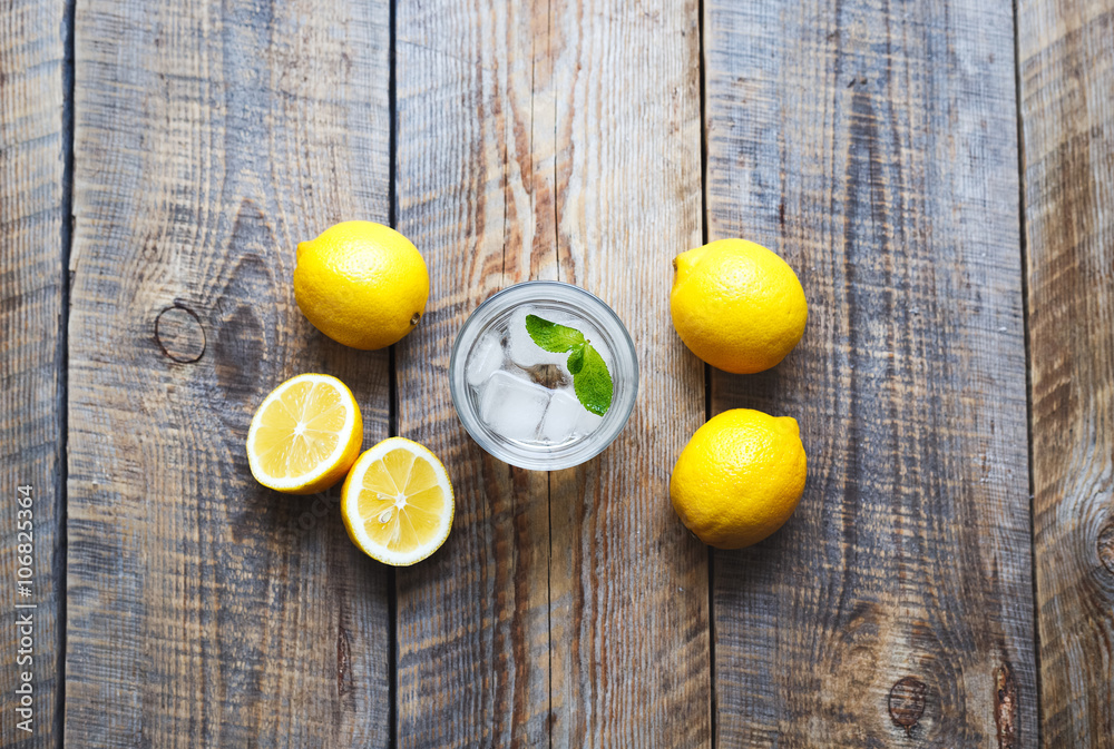 Lemonade with fresh lemon and mint on wooden background