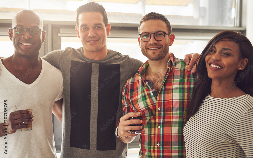 Four smiling adult friends in office