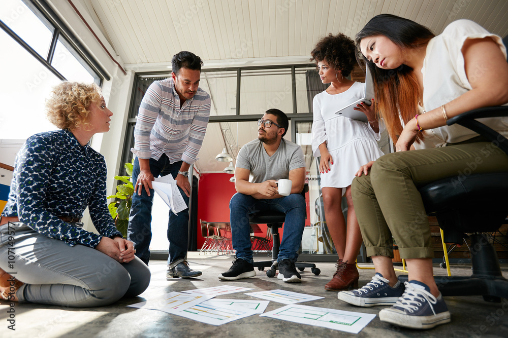 Creative team working on floor at work space