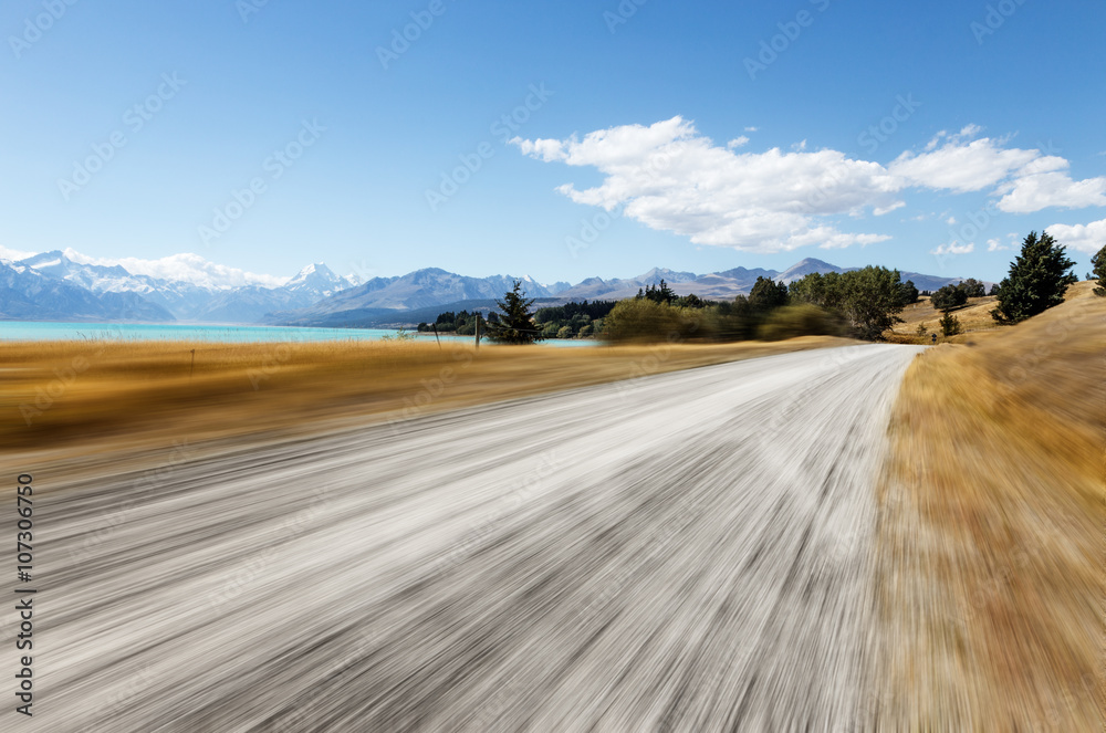 新西兰晴天穿过牧场的空旷乡村道路