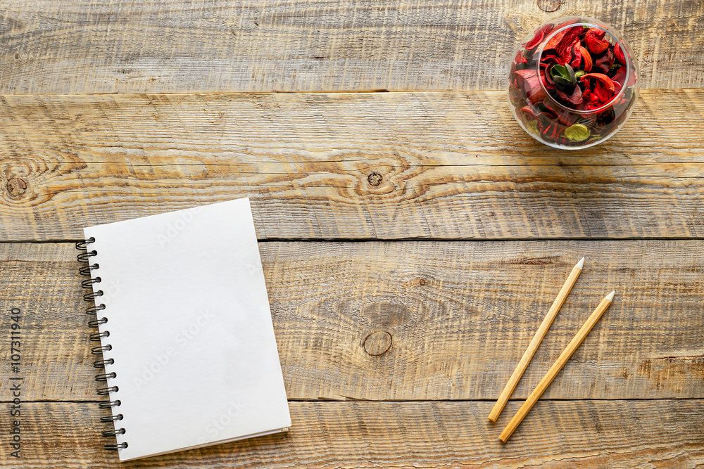 Composition of notebook and pencil at wooden table