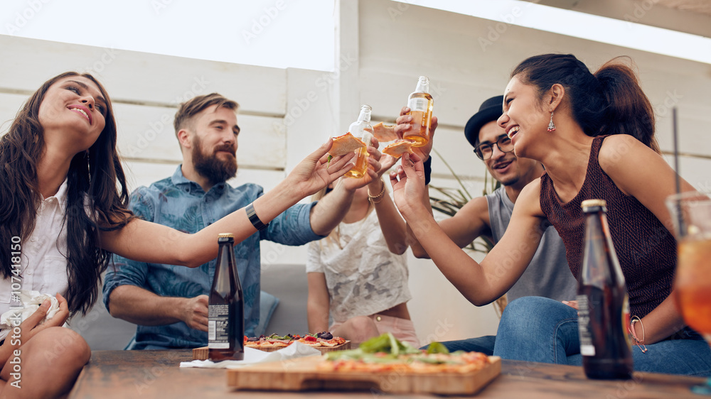 Group of friends toasting beers in a party