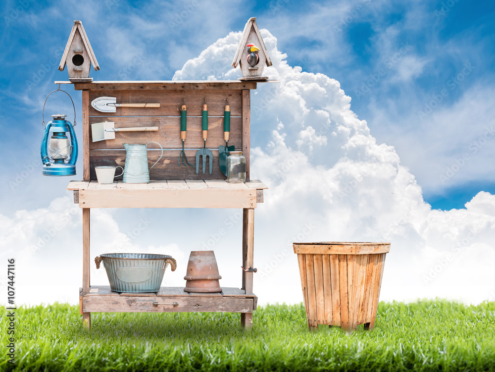 Gardening tools on vintage wooden table on grss