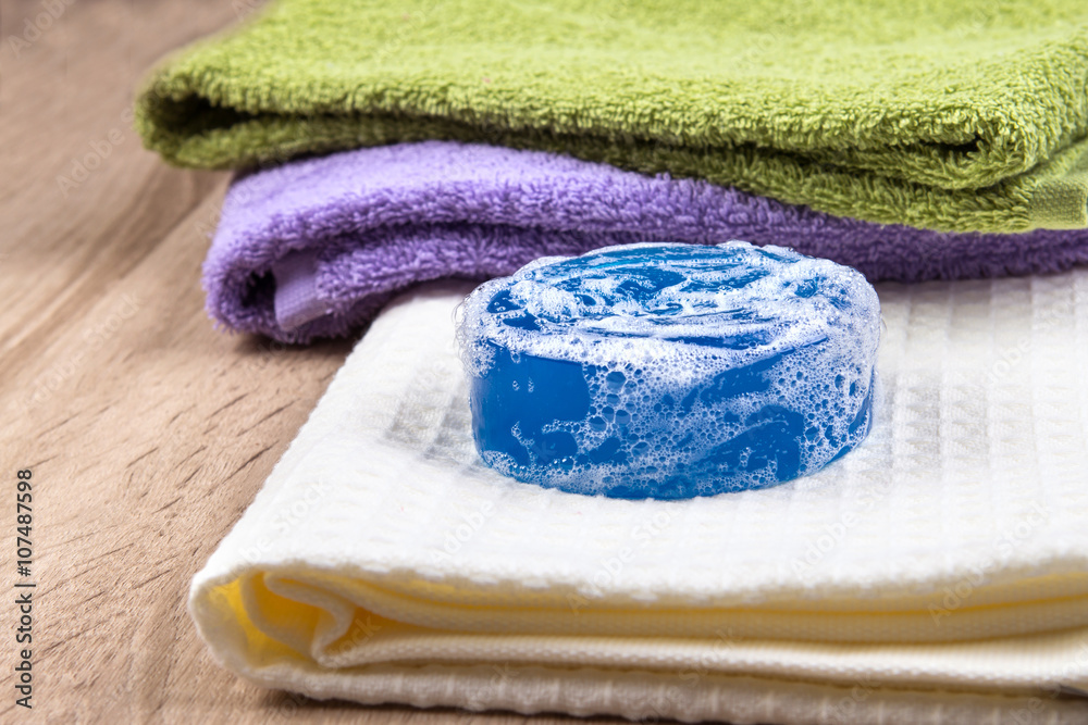 natural soap bar and bubble with bath towel on wooden background