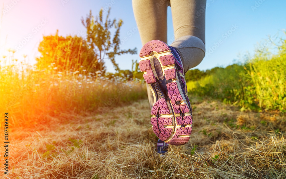 Woman running at sunset in a field