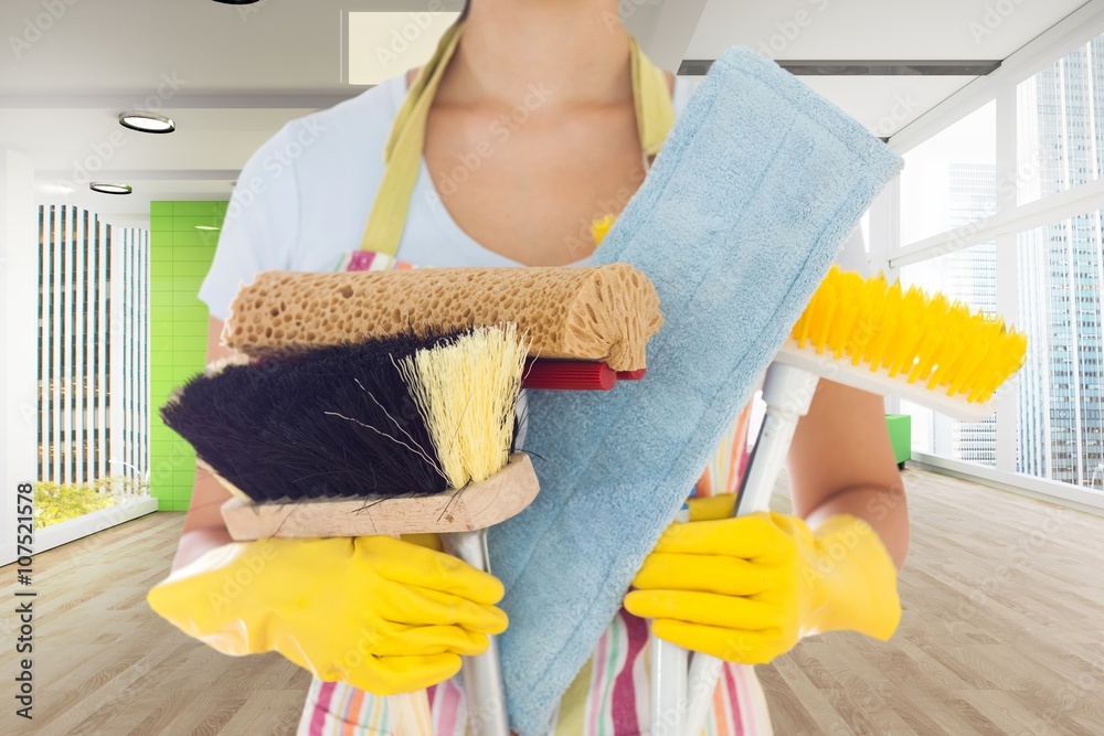 Composite image of woman holding brushes and mops