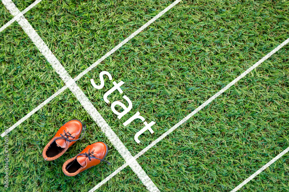 brown shoes standing on the grass field with the word start