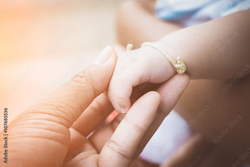 Close-up of mother and babys hands with soft focus