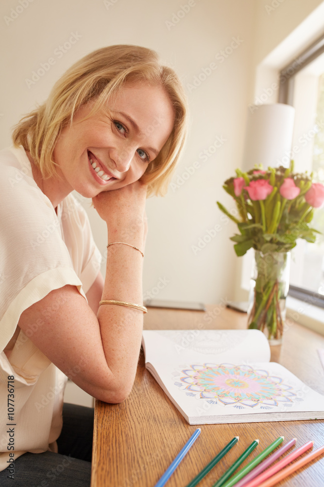 Relaxed woman with adult coloring book