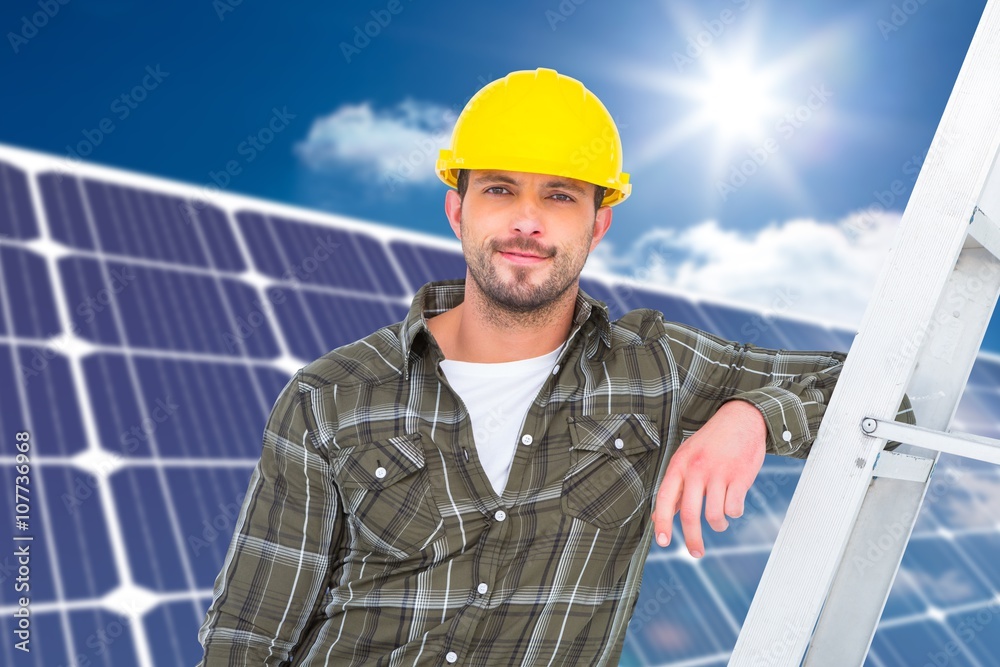 Composite image of smiling handyman in overalls leaning