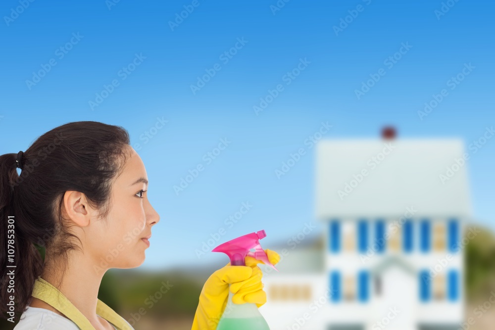 Composite image of woman spraying cleaning product