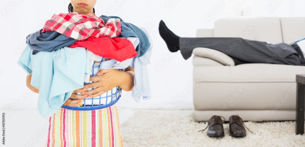 Composite image of tired woman holding full laundry basket