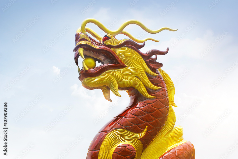 Chinese wooden carve dragon, red and golden colors on sky background