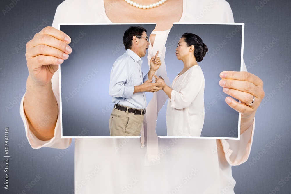 Composite image of woman holding a torn photo