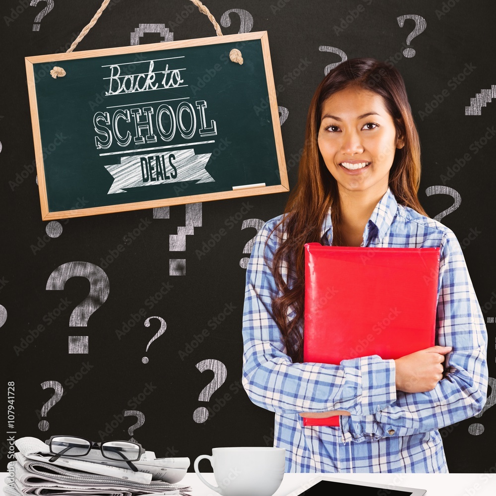 Composite image of smiling asian woman holding red book